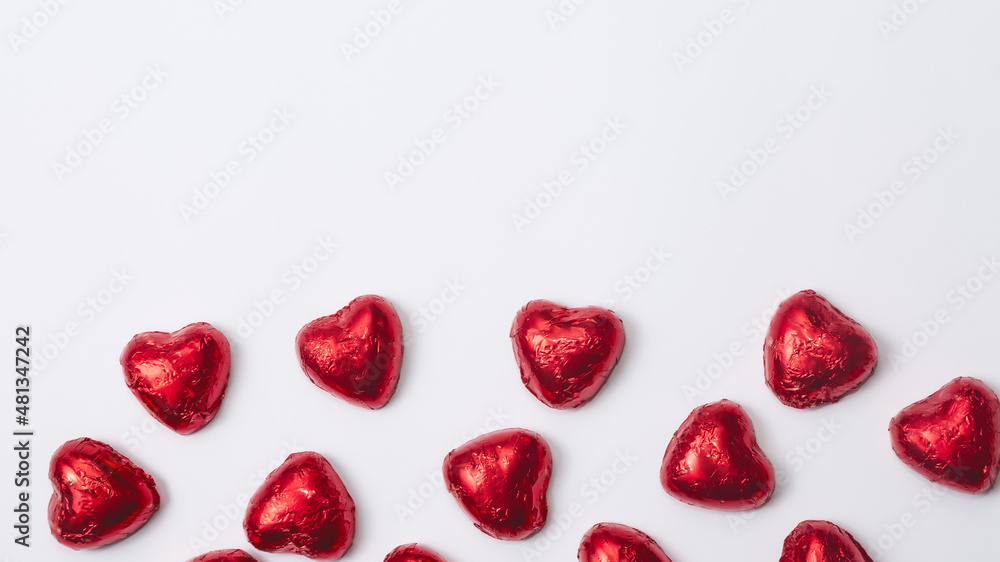 Red foiled chocolate hearts on a white background, chocolate hearts. Valentines day concept. Copy space Red foiled chocolate hearts on a white background, chocolate hearts. Valentines day concept. Copy space
