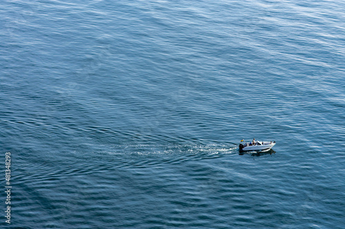 Boat in the water outside of Kullaberg, a natural reserve and mountain in the south of Sweden. Picture taken from high above, making the water pillar look very high. Boat going fast in Swedish-danish