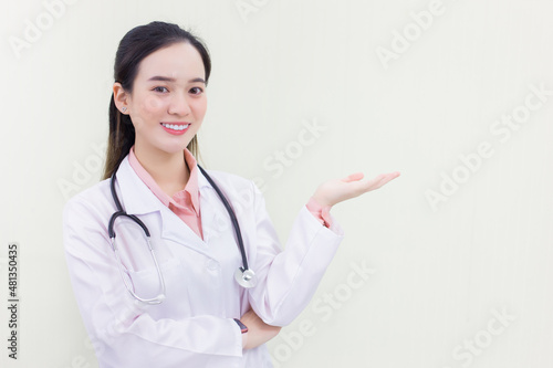 Professional Asian woman doctor shows her hand to present something while looking at the camera on white background.