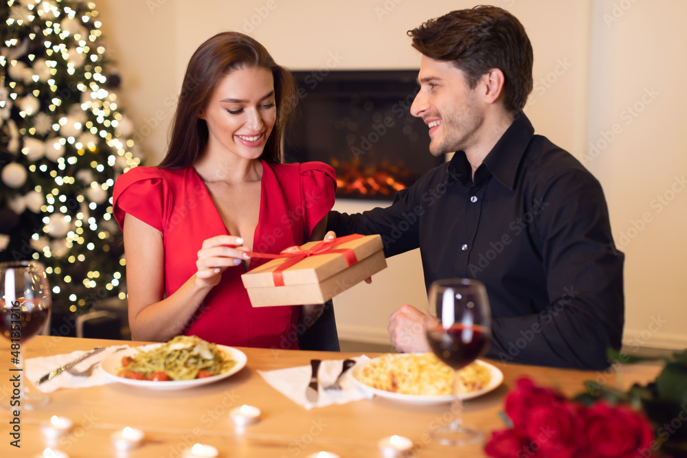 Excited woman unwrapping present from her boyfriend