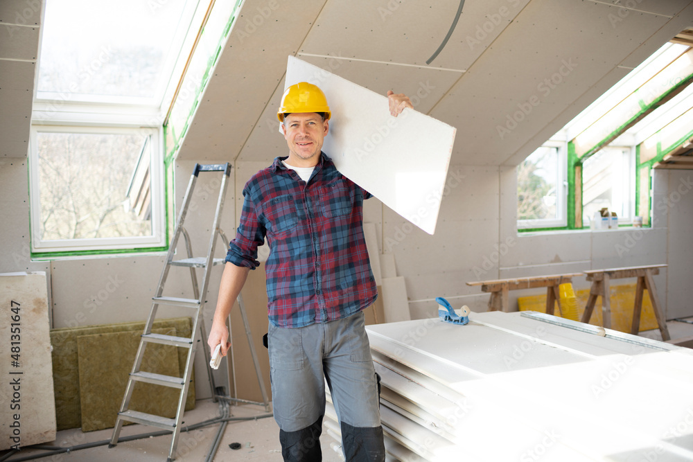 drywall worker with yellow safety helmet works on building site in a house drywall worker with yellow safety helmet works on building site in a house