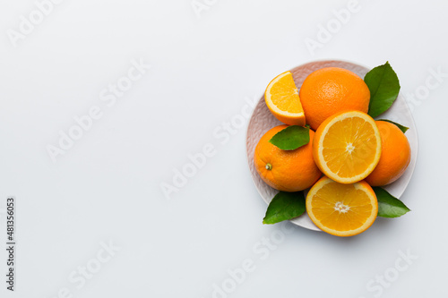 Flat lay of Fresh orange fruit with sliced in plate on Colored background. Top view with copy space