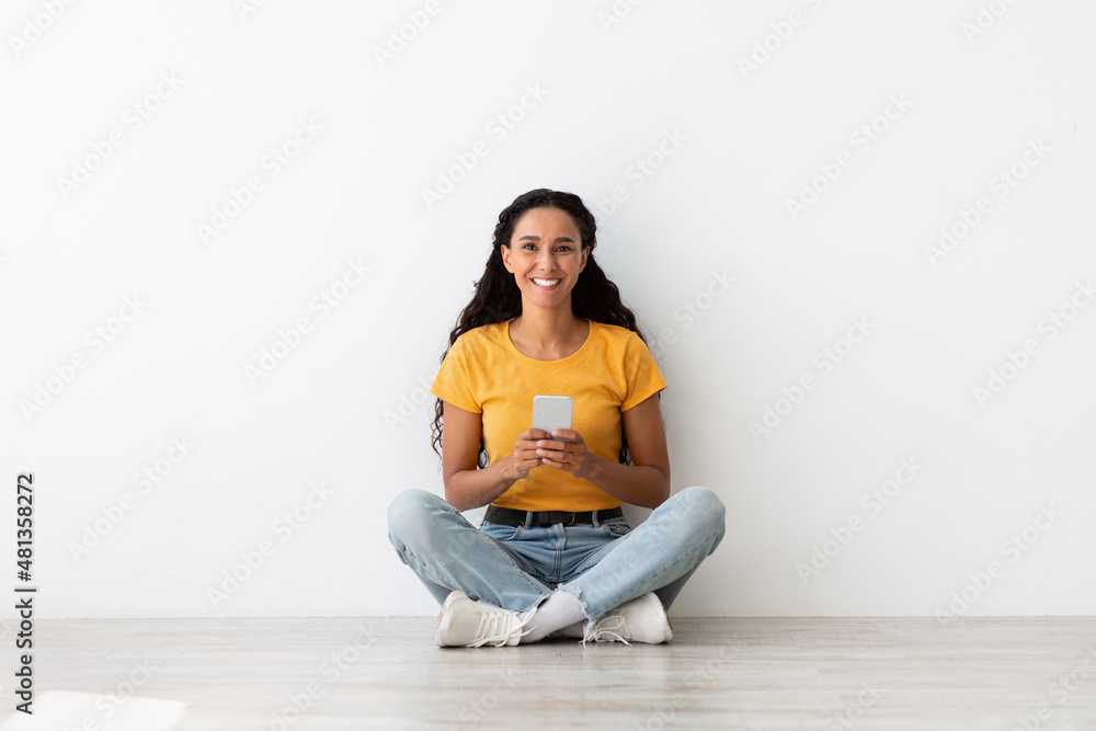 Mobile Communication. Happy Cheerful Young Female Sitting On Floor With Smartphone Mobile Communication. Happy Cheerful Young Female Sitting On Floor With Smartphone