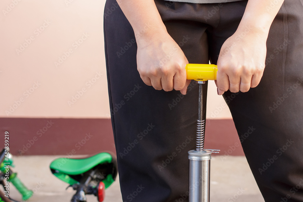 woman's hands pumping up a bike tire woman's hands pumping up a bike tire