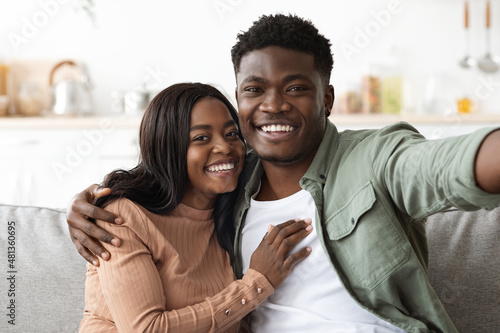 Cheerful african american man and woman taking photo together