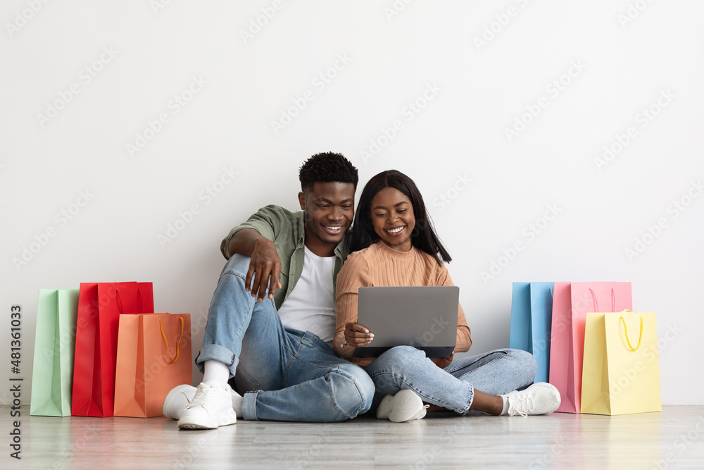 Beautiful black lovers using notebook, shopping online Beautiful black lovers using notebook, shopping online