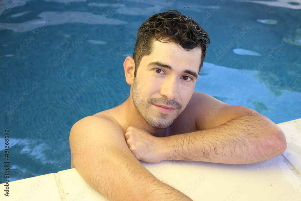 Natural looking young man in swimming pool Natural looking young man in swimming pool