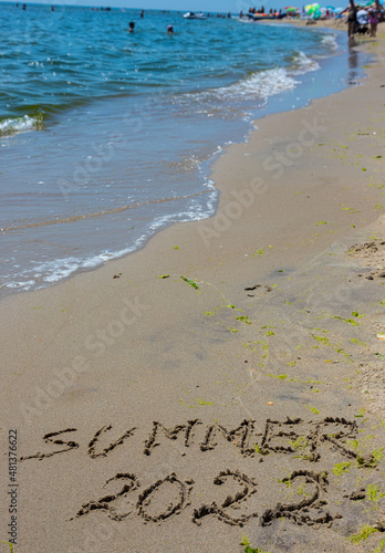 The inscription on the sand Summer symbolizes a summer 2022 vacation at the sea