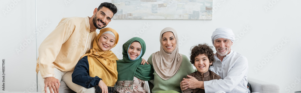 cheerful multicultural muslim family looking at camera at home, banner. cheerful multicultural muslim family looking at camera at home, banner.