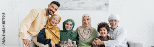 Fényképezés cheerful multicultural muslim family looking at camera at home, banner