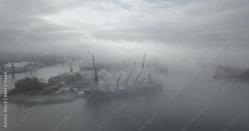 Drone flying over the port with cargo ships. Heavy fog, gloomy atmosphere. Big ship in the sun and fog. Drone flying over the port with cargo ships. Heavy fog, gloomy atmosphere. Big ship in the sun and fog.
