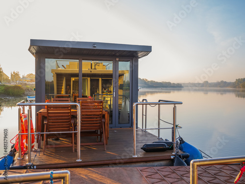 Canvas-taulu houseboat on a river in a early sunny morning