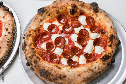 Fresh pizza pie with pepperoni on tray