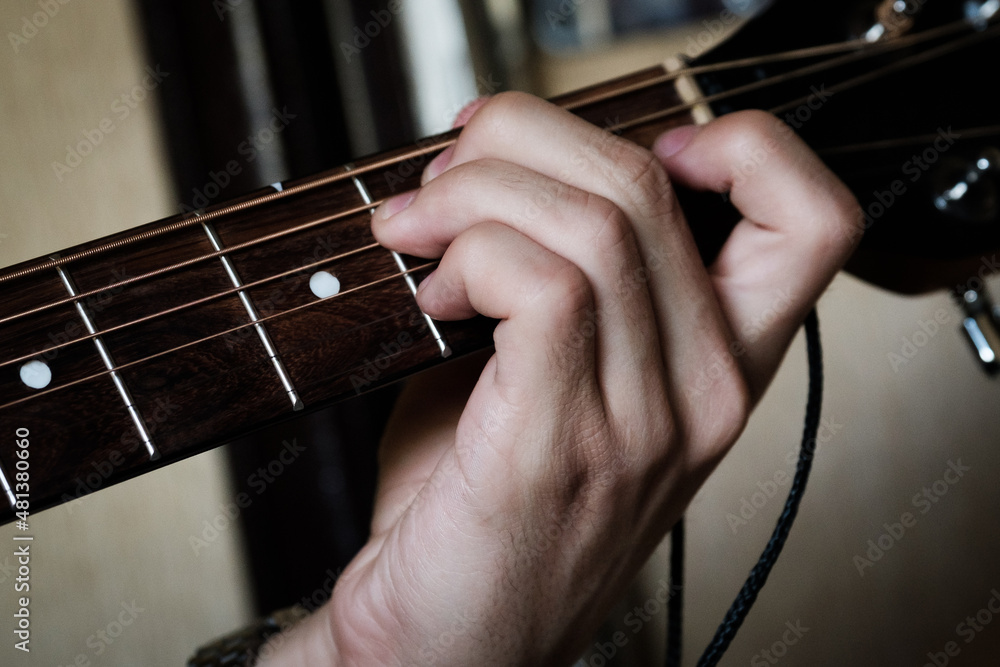 Hands hold the neck of the guitar, play it, pinching the strings with your fingers. Hands hold the neck of the guitar, play it, pinching the strings with your fingers.