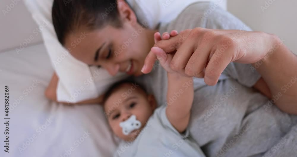 Young loving mother lying with her son on bed at home Young loving mother lying with her son on bed at home
