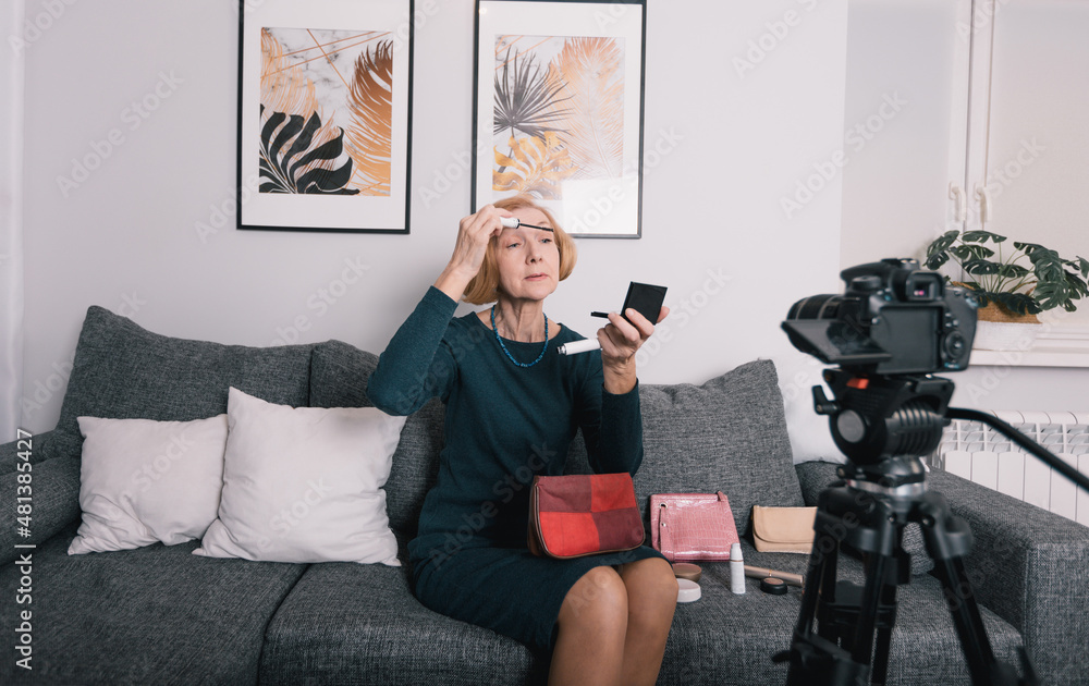 an elderly woman in the living room shoots a video for the network. advertises cosmetics. Online training, video blog an elderly woman in the living room shoots a video for the network. advertises cosmetics. Online training, video blog