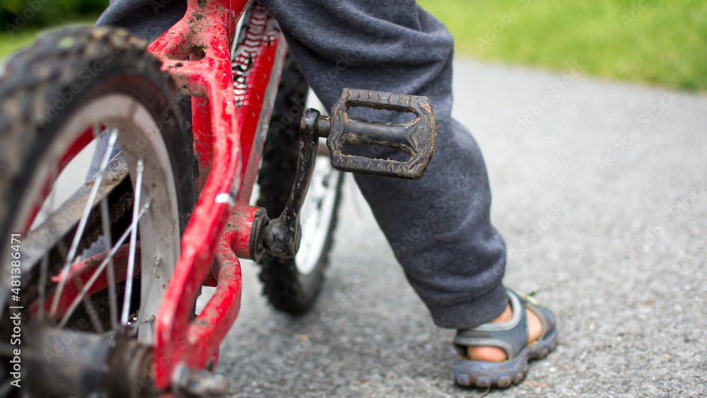 Little boy ride a bicycle. Small biker with dirty bike. Concept of sport, free, and challenge.