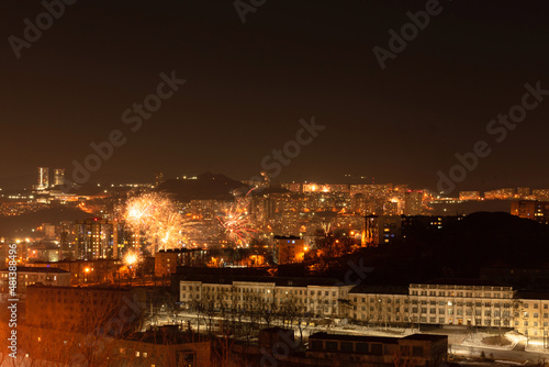 Fototapeta Naklejka Na Ścianę i Meble -  Fireworks in the city at night during New Year celebration. Soft focus background
