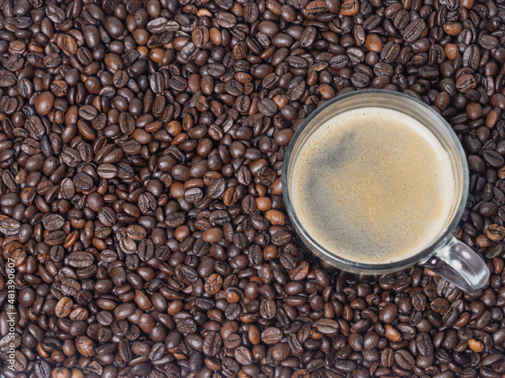 Glass, coffee cup with black coffee, on coffee beans. There is room for a background. View from above . Glass, coffee cup with black coffee, on coffee beans. There is room for a background. View from above .