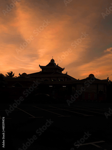Silhouette mosque with dramatic orange sky during sunset in Malaysia.