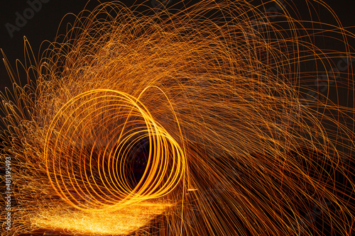 Image playing fireworks by rotating the wave shape of the lines, sparks to light. Amazing Fire Dance in the middle basin slope and beautiful reflection with copy space 