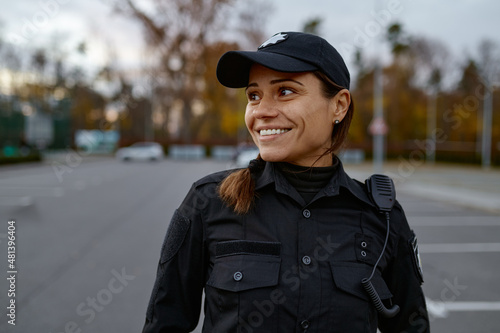 Tablou canvas Portrait of smiling police woman on street