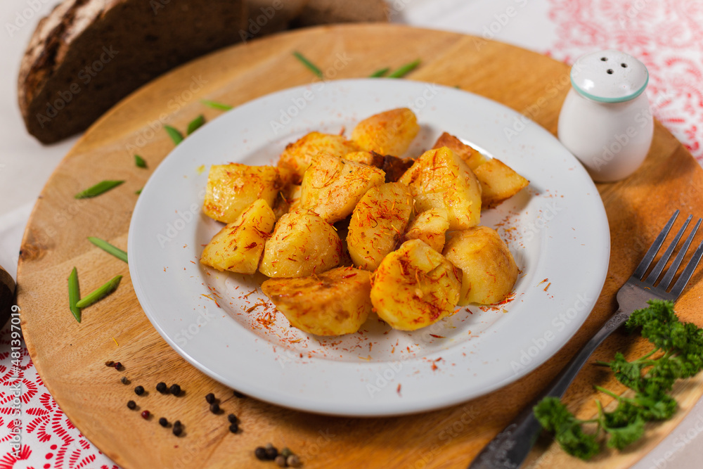 baked potatoes with a crust on a white plate and a wooden background in the cafe Russian cuisine baked potatoes with a crust on a white plate and a wooden background in the cafe Russian cuisine