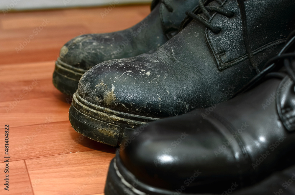Clean and dirty black shoes on the floor, close-up.
