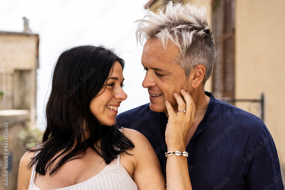 Trendy couple laughing with a white perfect smile - Middle age cool man and trendy young woman looking each other outdoors during a travel at historical city Trendy couple laughing with a white perfect smile - Middle age cool man and trendy young woman looking each other outdoors during a travel at historical city