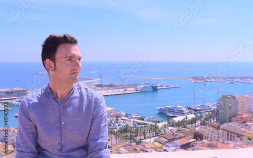 Portrait Happy good looking caucasic man at elevated point next to the beach in spring. Concept holiday copy space. Harbor background