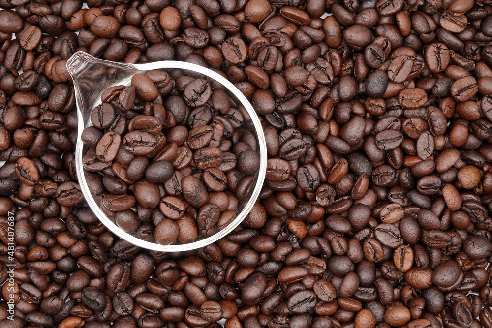 Fototapeta premium Closeup coffee bean background with glass spoon.