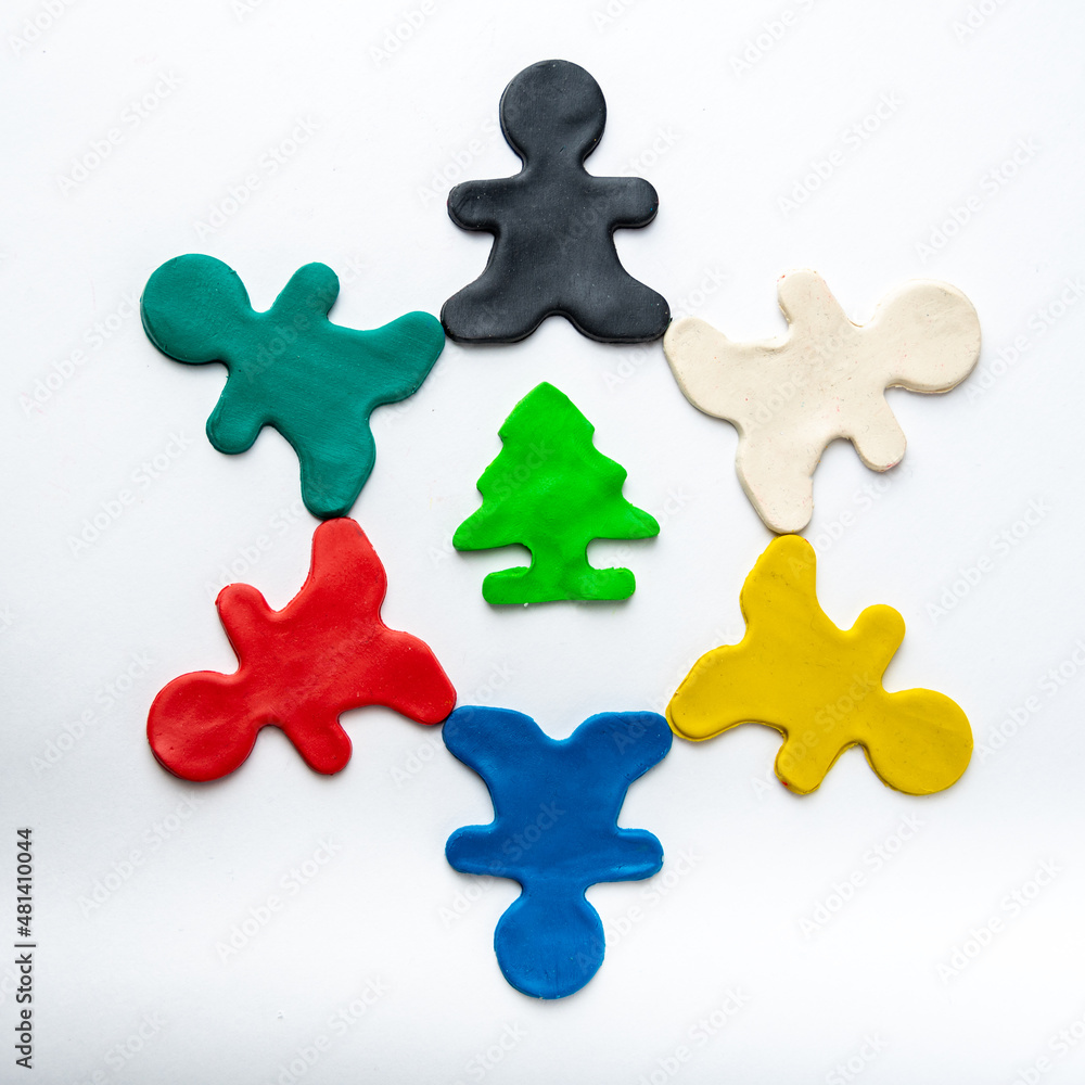 Multicolored bright plasticine men in a circle in the center of a green tree isolated on a white background. Eco-friendly concept Multicolored bright plasticine men in a circle in the center of a green tree isolated on a white background. Eco-friendly concept