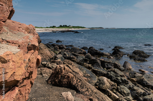 Scenic rocky shoreline near ocean on sunny day in Rhode Island