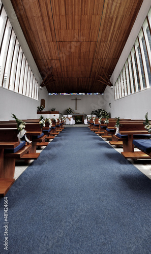 inside a church, you can see the cross in the background and the benches at the sides.