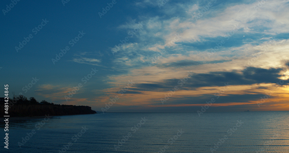 Panoramic coastline view with sky. Meditative sea surface reflecting sunlights. Panoramic coastline view with sky. Meditative sea surface reflecting sunlights.