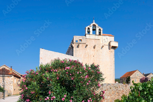 Old church building with belfry in Vrboska village, Hvar island, Dalmatia, Croatia, Europe. Travel and vacation destination. Old fisherman village, famous tourist attraction.