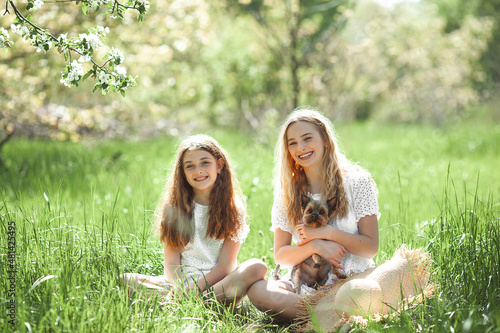 Two pretty girls with their dog photo