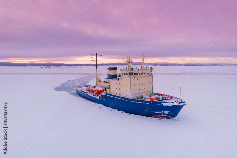 Fototapeta premium Icebreaking vessel in Arctic with background of sunset