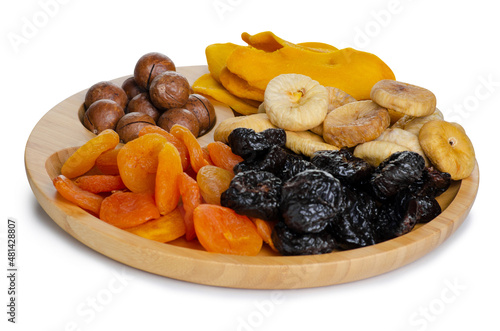 Wooden plate with dried fruits and nuts on white background isolation