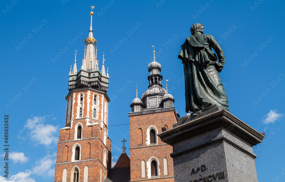 Famous Saint Mary's Basilica (Mariacki Church Kraków) and Adam Mickiewicz Monument at the Main Market Square in the Old Town district of Krakow, Poland.