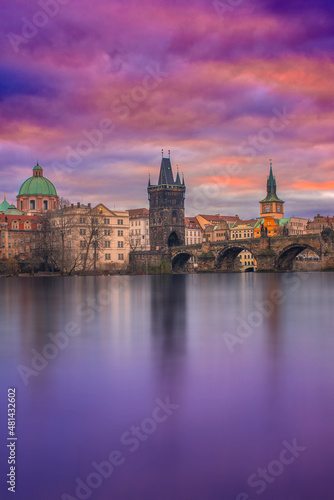 View from the Vltava river of the Charles Bridge in Prague, Czechia at sunrise. Colorful clouds © Marius Igas