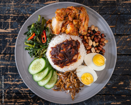 Nasi Lemak is a rice dish infused with coconut cream and laden with deep-fried fish or fried chicken. photo