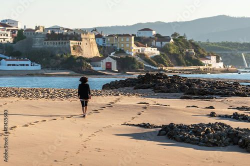 Woman walking along Praia da Franquia. Vila Nova de Milfontes photo
