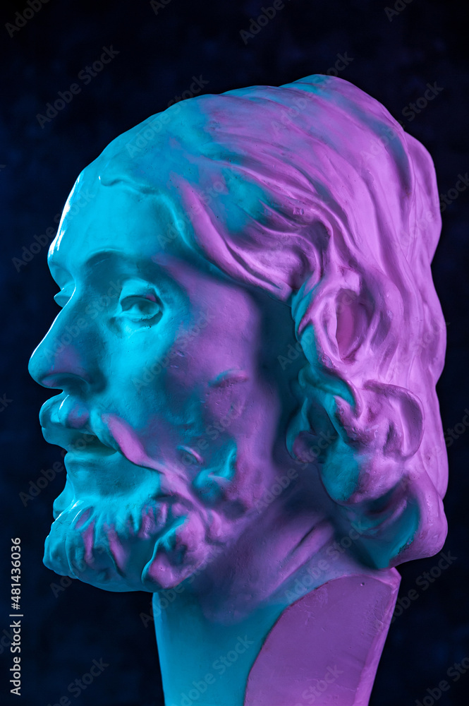 Colorful gypsum copy of ancient statue of John the Baptist head for artists on a dark textured background. Plaster sculpture man face. John baptized Jesus. Art poster in purple and blue bright colors. Colorful gypsum copy of ancient statue of John the Baptist head for artists on a dark textured background. Plaster sculpture man face. John baptized Jesus. Art poster in purple and blue bright colors.