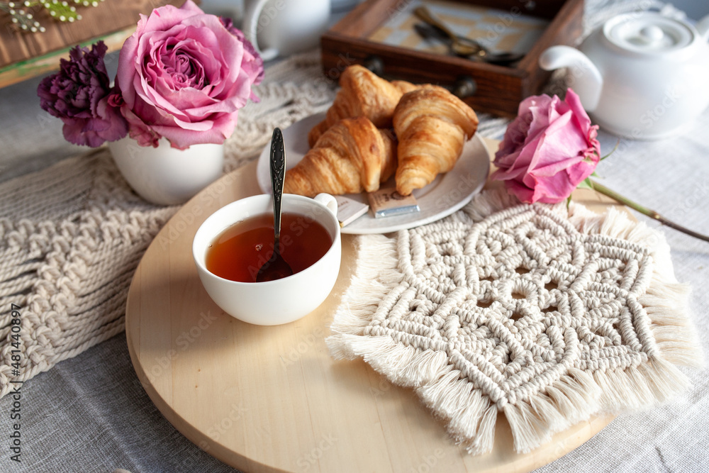 Beautiful cozy breakfast, croissants and tea, the table is decorated with macrame napkins Beautiful cozy breakfast, croissants and tea, the table is decorated with macrame napkins