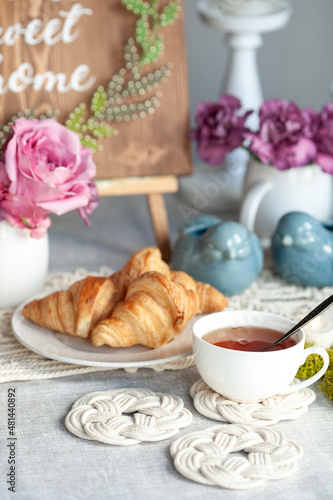 Beautiful cozy breakfast, croissants and tea, the table is decorated with macrame napkins