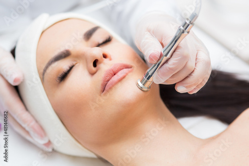 portrait of a woman receiving diamond microdermabrasion treatment. skin care, beauty salon, close up photo