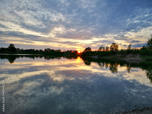 sunset on the lake with reflection. In the horizon row of trees. © RSK Foto Schulz