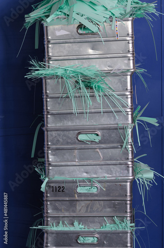 Vier aluminium Kisten gestapelt, mit grünen Papierstreifen, frontal photo