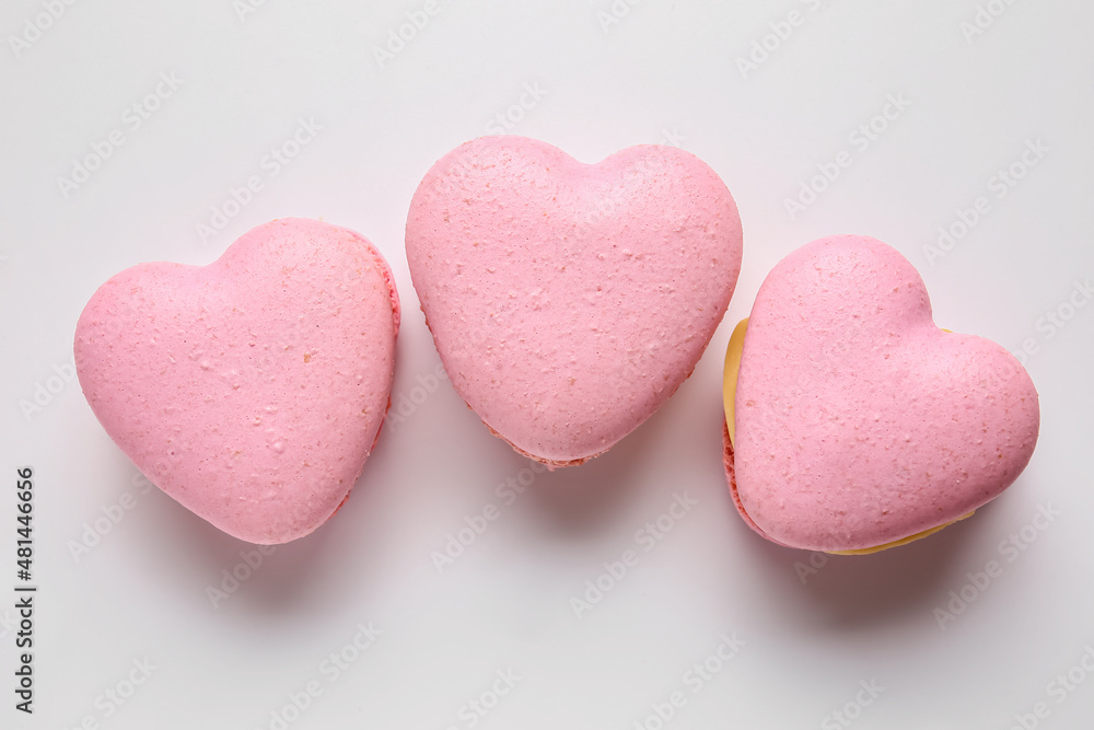 Tasty heart-shaped macaroons on white background Tasty heart-shaped macaroons on white background
